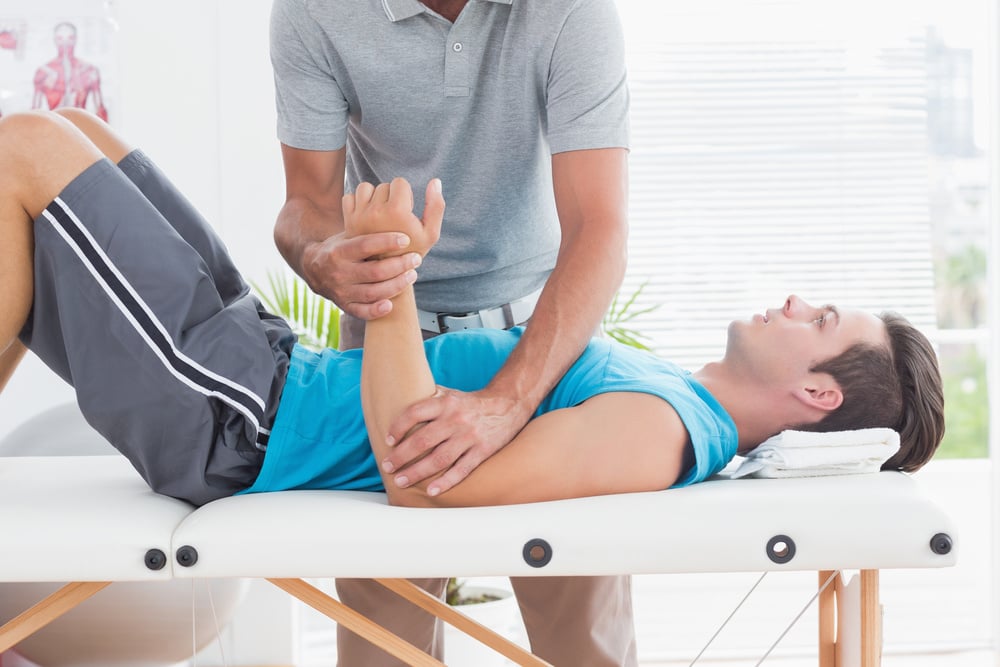 Doctor examining his patient arm in medical office