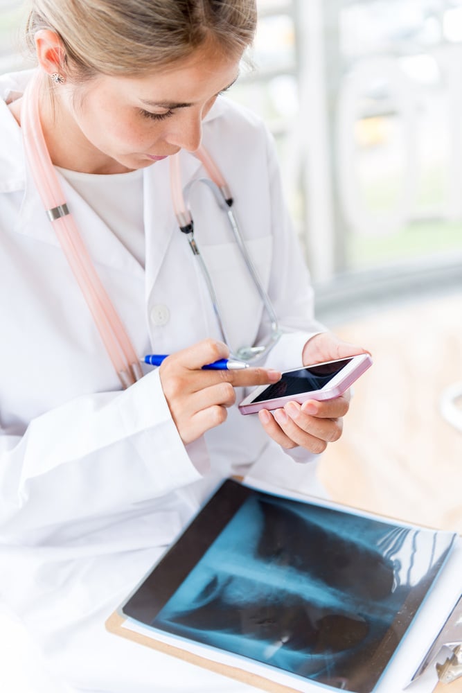 Female doctor working at the hospital and using a smart phone